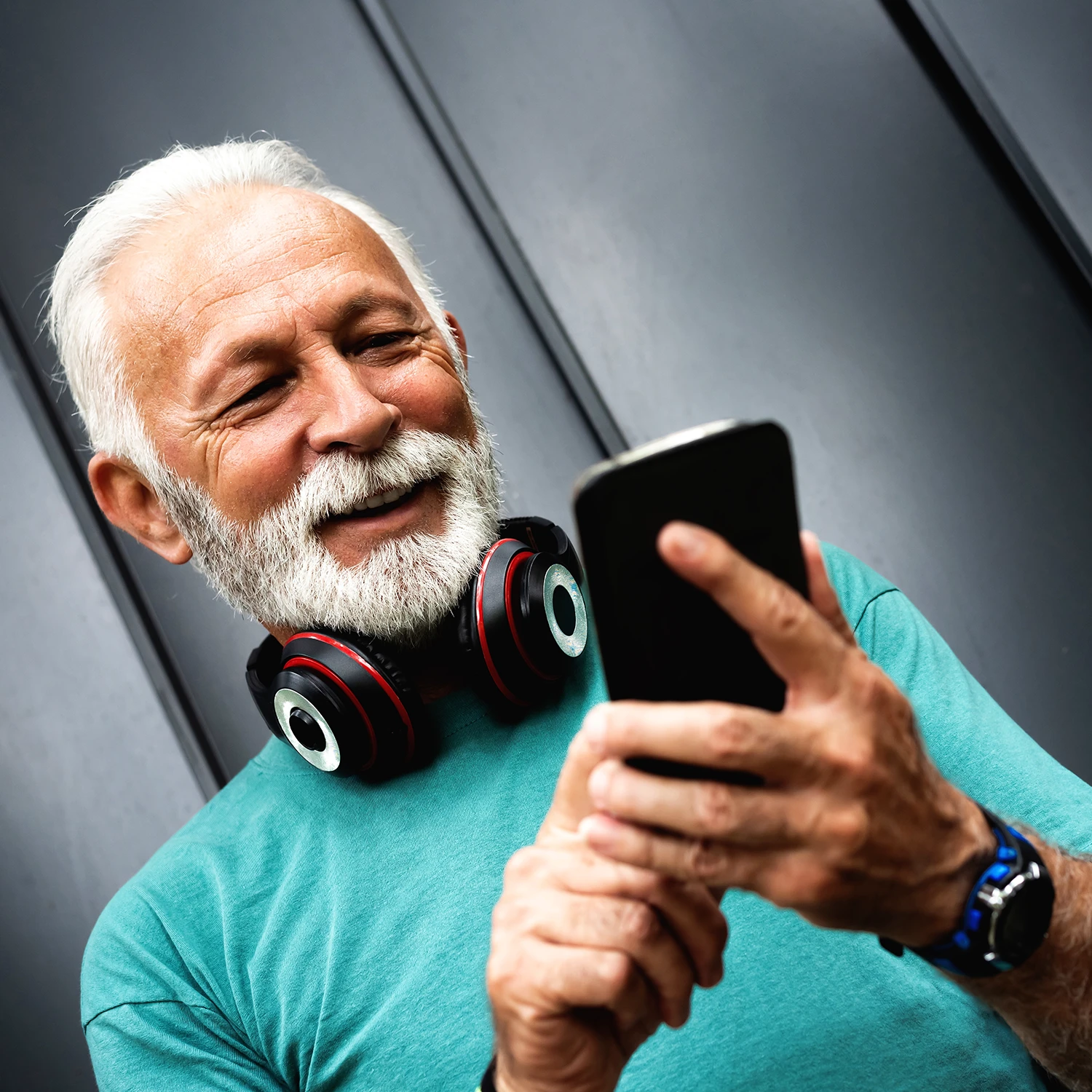 Homme âgé satisfait de son smartphone qui lui facilite le quotidien.